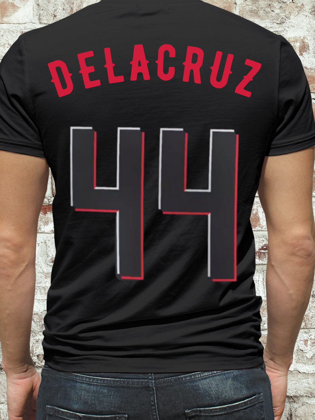 Black t-shirt featuring a stylized illustration of a baseball player with long hair and white gloves, layered gold chains, and a retro triangle backdrop, with the word "grandtheft" in bold cursive lettering.

