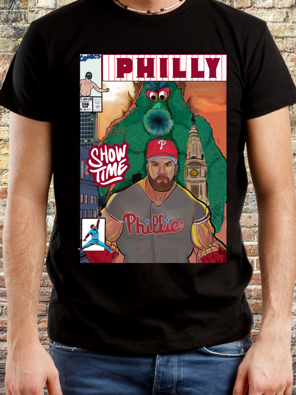 Black t-shirt featuring a comic book cover design with a muscular baseball player, a large green mascot, and Philadelphia skyline in the background — bold artwork with 'PHILLY' and 'Show Time' text, perfect for passionate Philly baseball fans