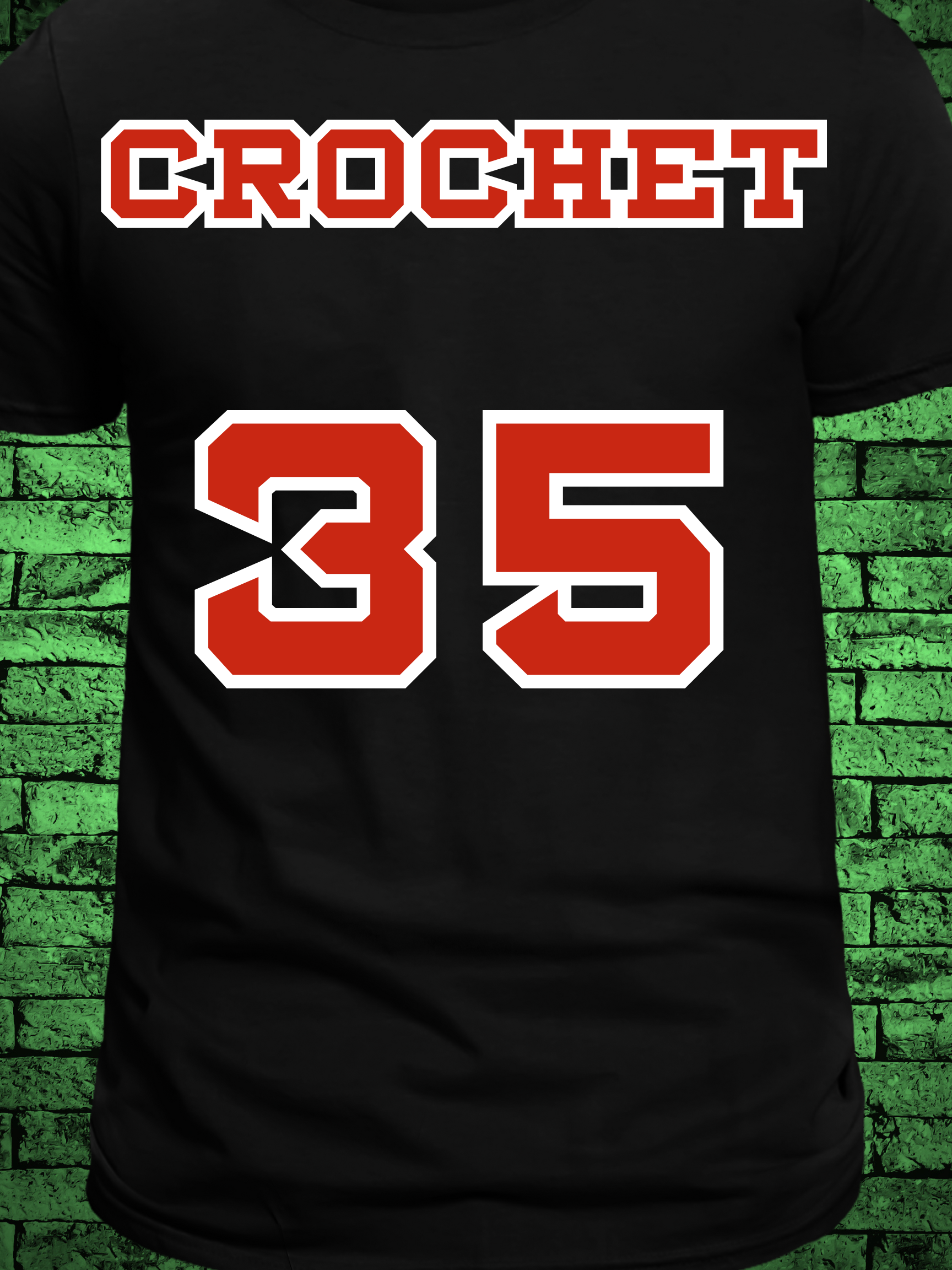 Black t-shirt featuring a comic book-style design titled "The Amazing Crochet," showcasing a baseball player in a red jersey with the name "Crochet" and number 5, pitching in front of a yarn ball and crochet hooks with the phrase “Knitta Please!”