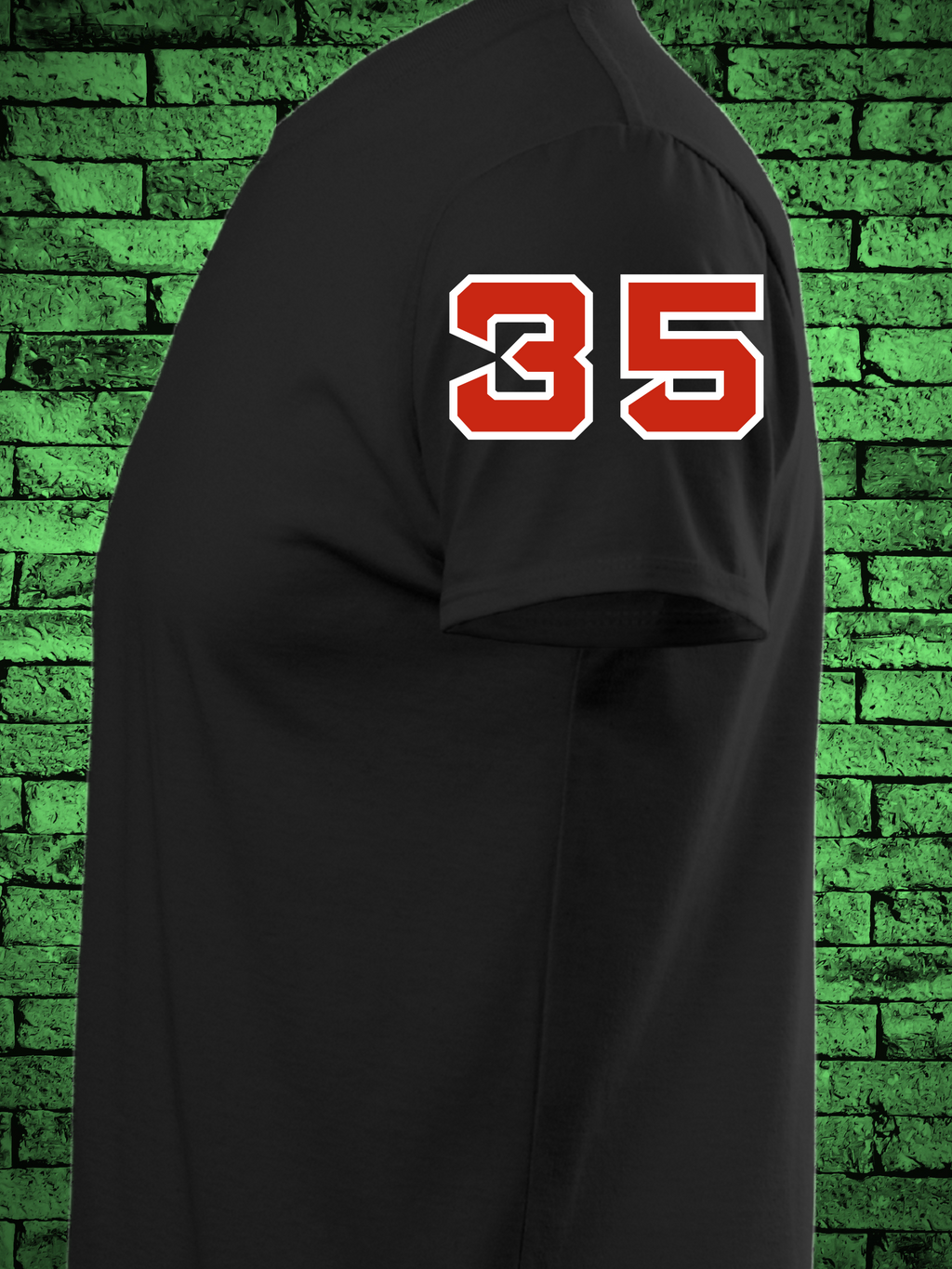 Black t-shirt featuring a comic book-style design titled "The Amazing Crochet," showcasing a baseball player in a red jersey with the name "Crochet" and number 5, pitching in front of a yarn ball and crochet hooks with the phrase “Knitta Please!”