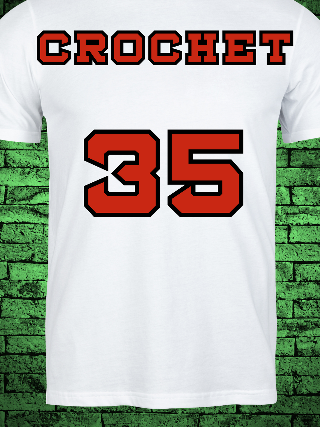 White t-shirt featuring a comic book-style design titled "The Amazing Crochet," showcasing a baseball player in a red jersey with the name "Crochet" and number 5, pitching in front of a yarn ball and crochet hooks with the phrase “Knitta Please!”